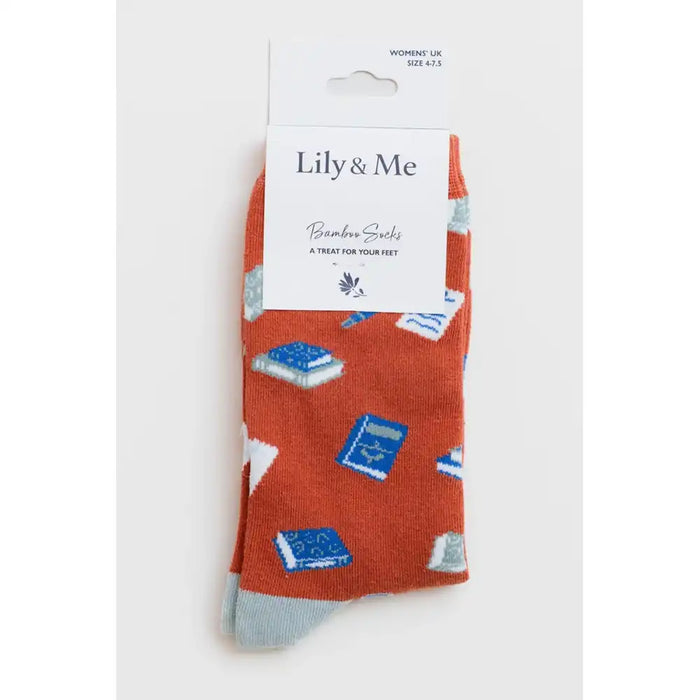A pair of Lily & Me bamboo socks in rust orange with a blue and white book pattern, shown on a white background with their retail header card.