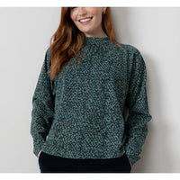 Woman wearing a green floral blouse against a plain background