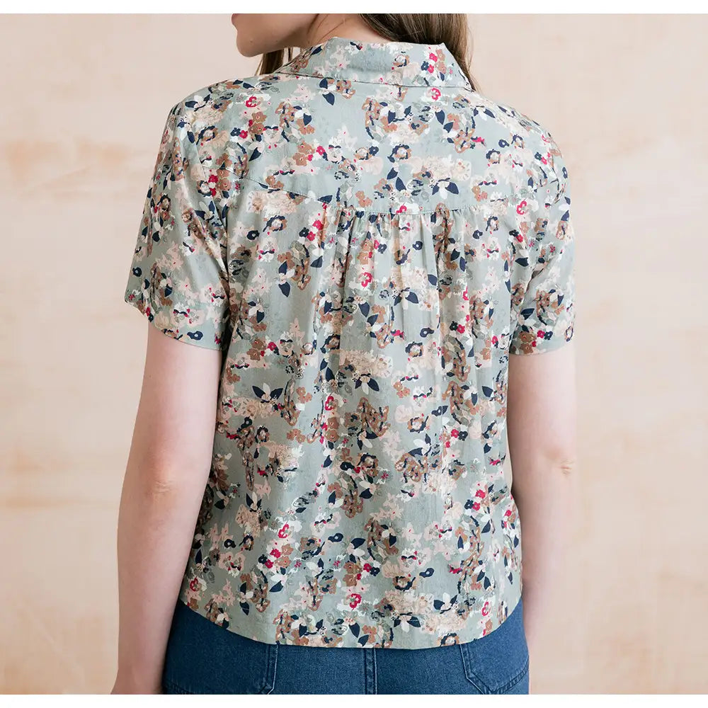 Floral patterned shirt worn by a person on a beige background