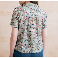 Floral patterned shirt worn by a person on a beige background