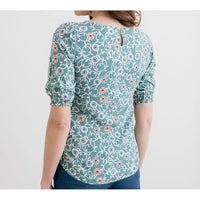 Woman wearing a floral patterned blouse on a white background