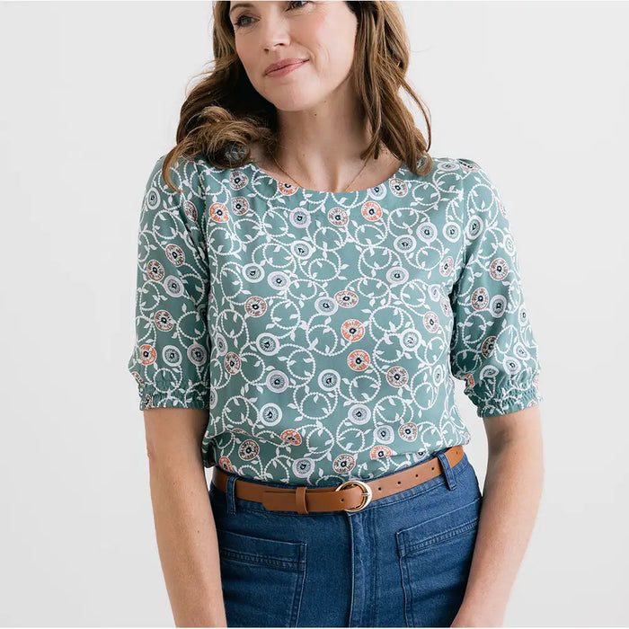 Woman wearing a floral patterned blouse with a plain background