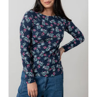 Woman wearing a navy blue long-sleeve top with floral pattern against a plain background