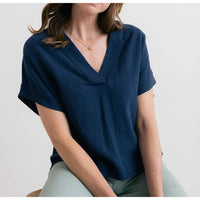 Person wearing a navy blue top sitting on a white background