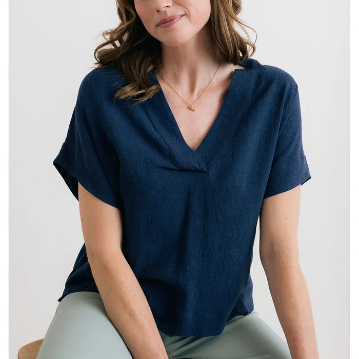 Woman wearing a blue top sitting on a white background