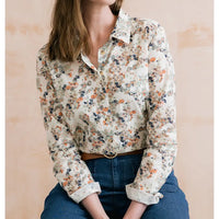 Ecru based shirt with collar and long turned up sleeves. Has a delicate floral pattern on it. 