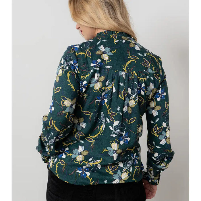 Person wearing a green floral patterned shirt against a plain background