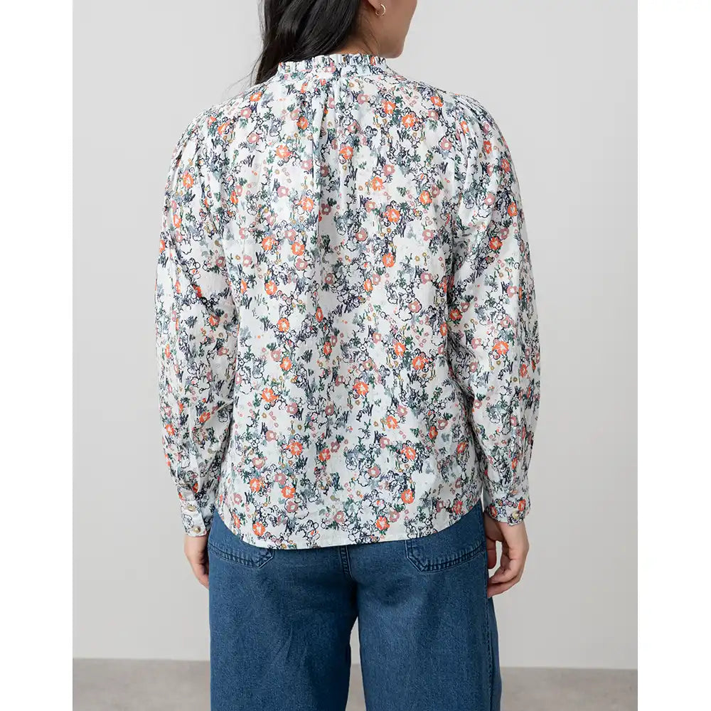 Person wearing a floral shirt with a plain background