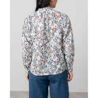 Person wearing a floral shirt with a plain background