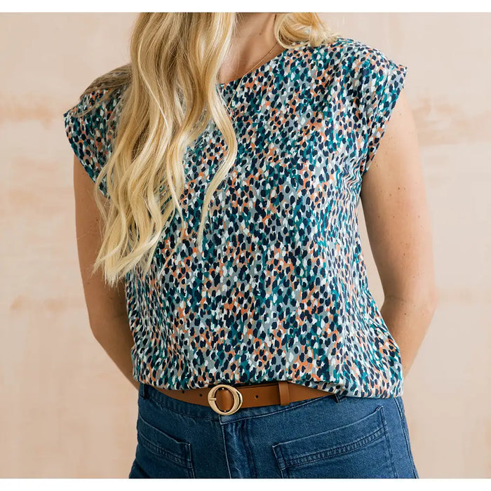 Blue dappled top with short sleeves and hints of orange in it.