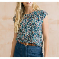 Blue dappled top with short sleeves and hints of orange in it.
