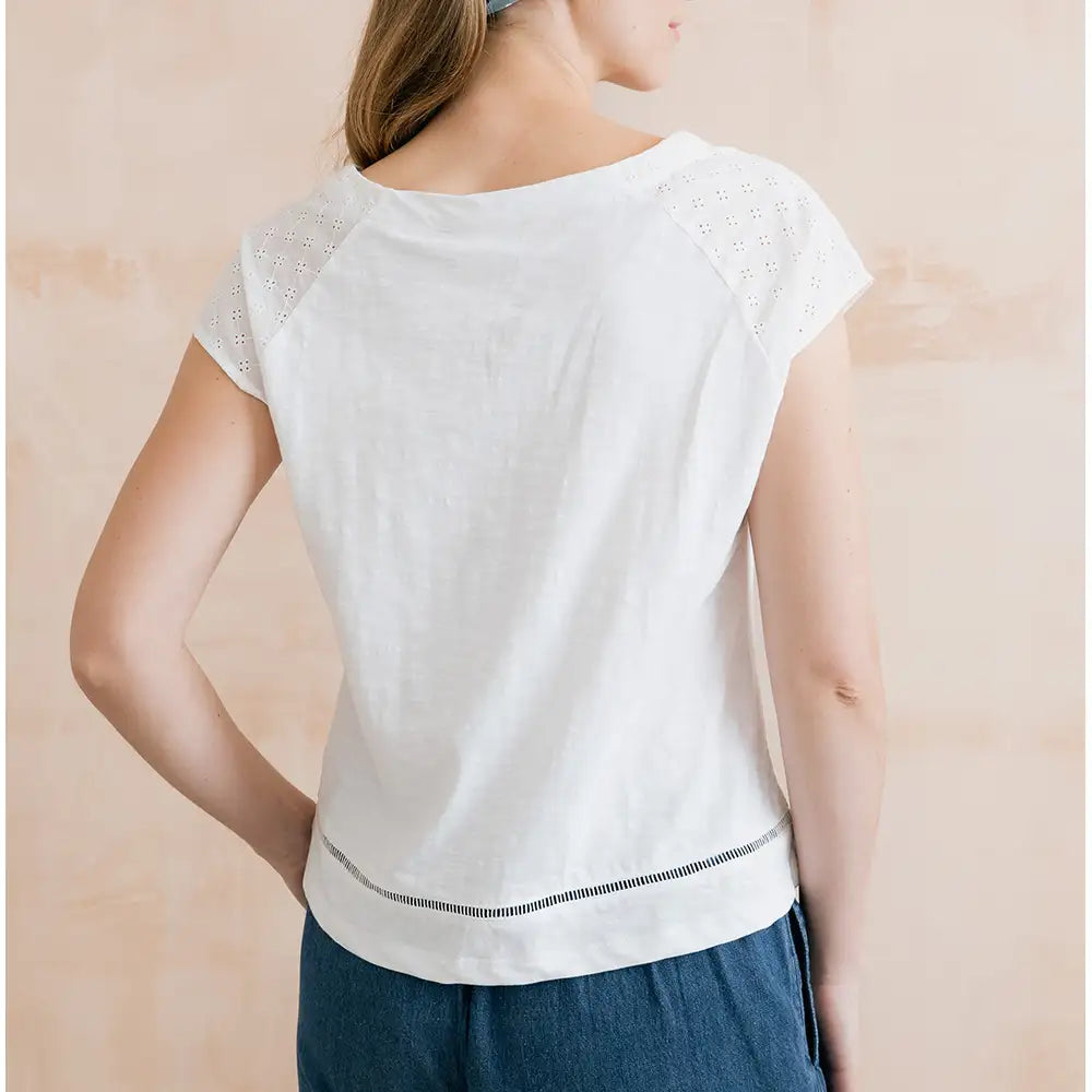 Round neck, short sleeve top in white. Broderie detail just above the hem