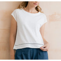 Round neck, short sleeve top in white. Broderie detail just above the hem