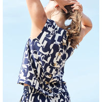 Person wearing a navy and white patterned outfit against a clear blue sky