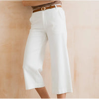 White wide-leg pants with a brown belt on a beige background