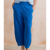 Blue pants worn by a person against a wooden background