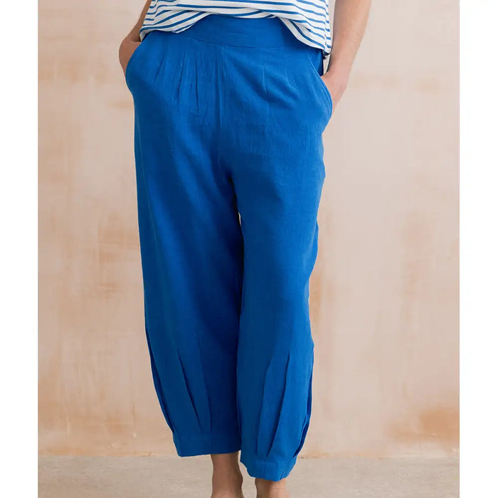 Blue pants worn by a person against a wooden background