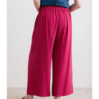 Person wearing bright pink wide-leg pants with a plain background