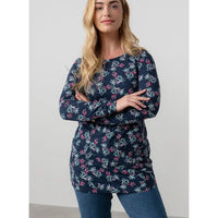 Woman wearing a navy floral long-sleeve top against a white background