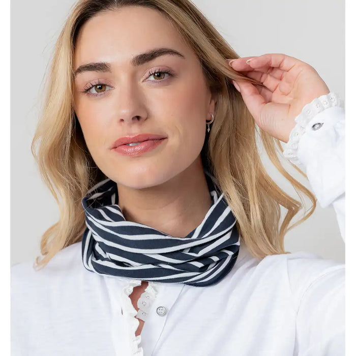 Woman wearing a navy and white striped scarf with a plain background