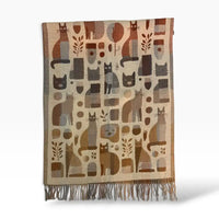 A woven scarf with a beige and brown abstract pattern featuring stylized cat silhouettes, fringed ends