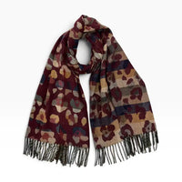 Bungundy coloured scarf with tassels and a bige leopard print all over it. On a white background.