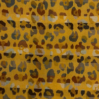 Mustard coloured scarf with tassels. Beige and grey leopard print all over it. 