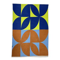 Colorful geometric patterned rug with blue, green, and brown shapes on a white background