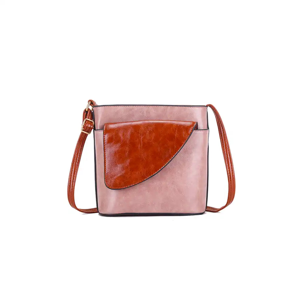 Pink crossbody bag with brown faux leather flap on a white background