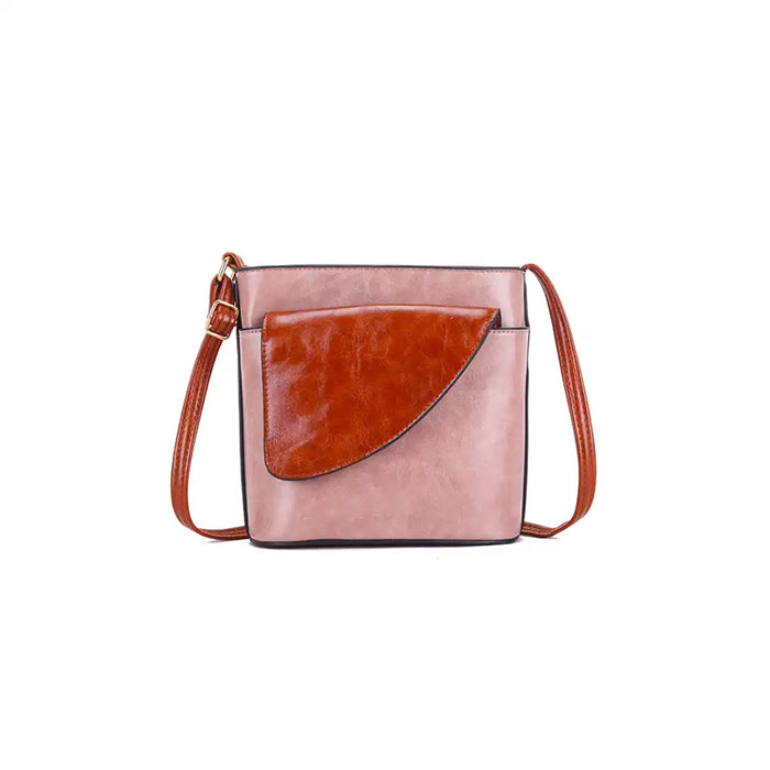 Pink crossbody bag with brown faux leather flap on a white background