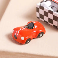 Red toy car on a checkered background