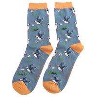A pair of blue crew socks with flying puffins and yellow heels, cuffs and toes, shown against a plain white background.