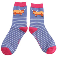 Pair of socks with striped pattern and  Highland Cow design on a white background.
