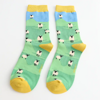 Pair of socks with sheep pattern on a green background
