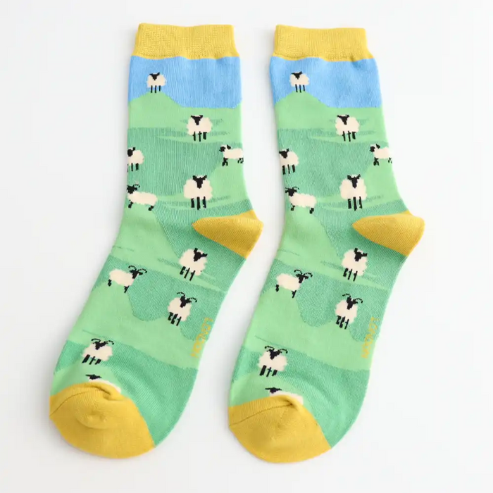 Pair of socks with sheep pattern on a green background
