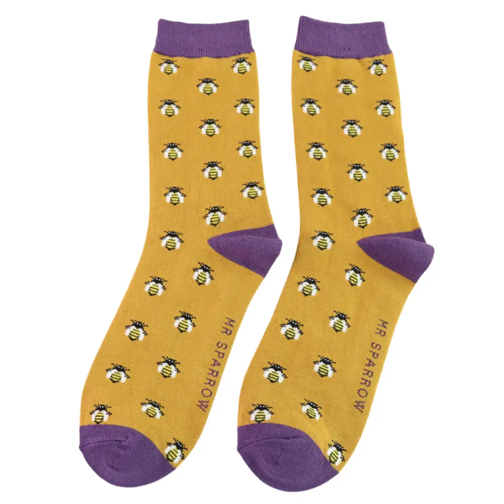 Golden yellow socks with honey bee design on a white background