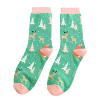 Green socks with deer and tree pattern on a white background