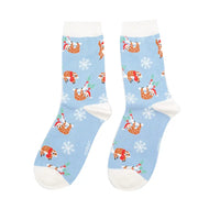 Pair of socks with Santa Claus and reindeer pattern on a light blue background