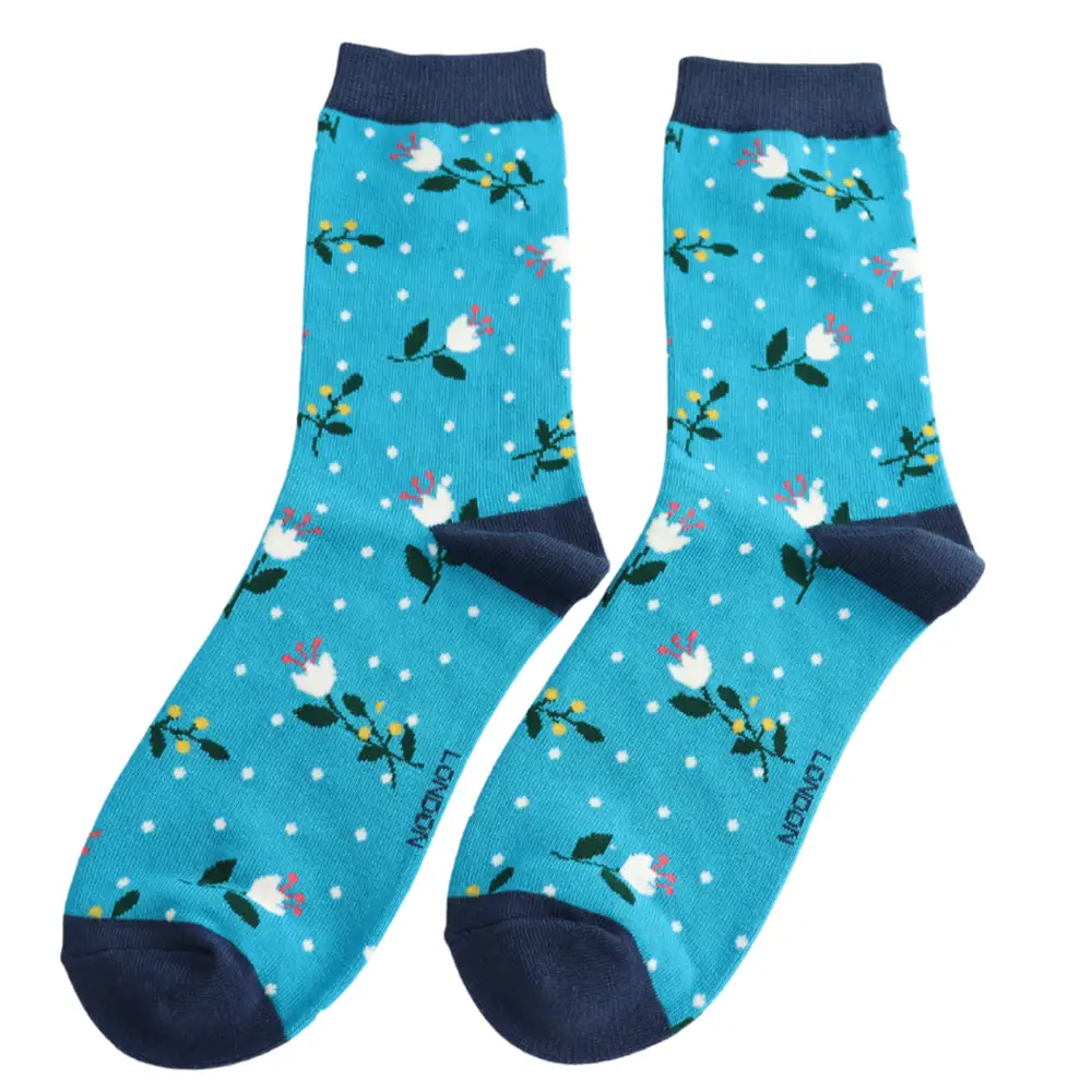 Floral-patterned socks with green accents on a teal background