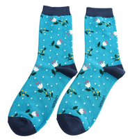 Floral-patterned socks with green accents on a teal background