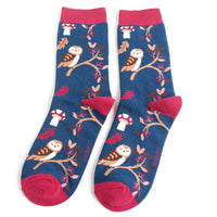 A pair of navy blue crew socks with woodland plants and owls burgundy heels, cuffs and toes, shown against a plain white background.