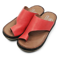 Pair of red sandals with brown soles on a white background