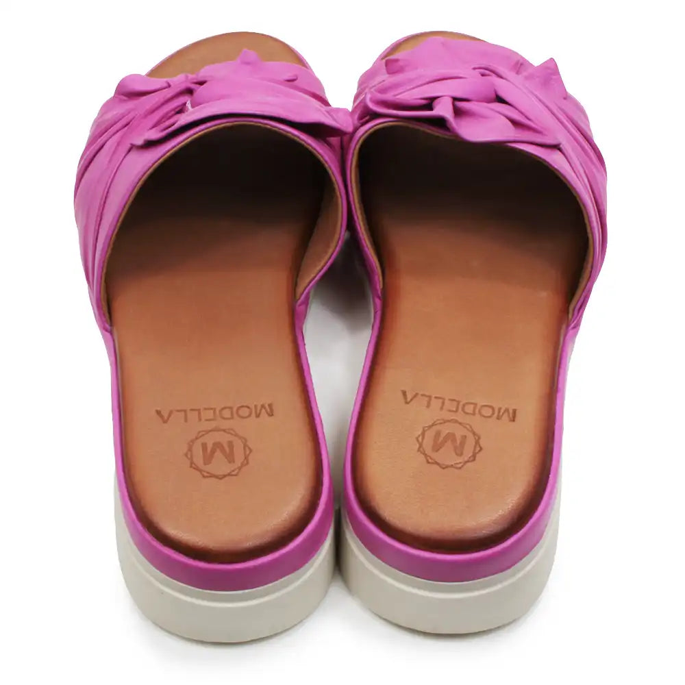Pair of pink sandals with brown soles on a white background