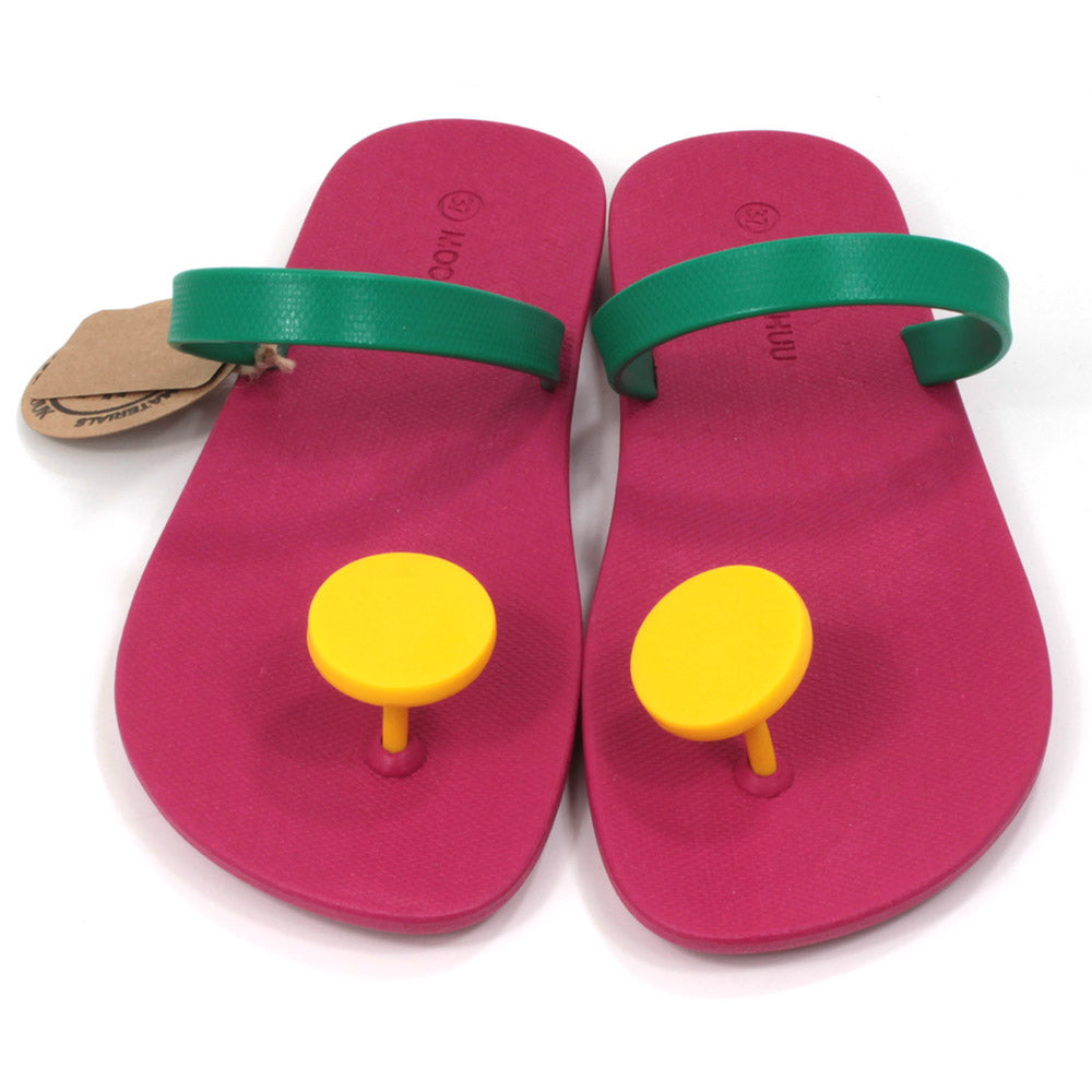 Slider sandals with bright cerise soles, green over the foot strap and large bright yellow 'dot' toe posts. All made from recycled rubber. Front view.