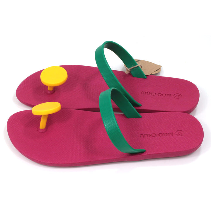Slider sandals with bright cerise soles, green over the foot strap and large bright yellow 'dot' toe posts. All made from recycled rubber. Side view.