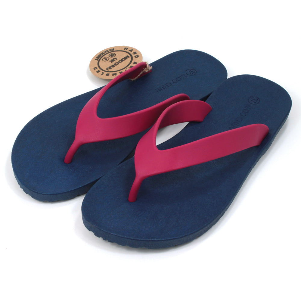 Toe post flip flops with navy blue soles and cerise foot straps. All made from recycled rubber. Angled view.