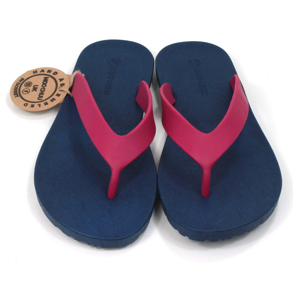 Toe post flip flops with navy blue soles and cerise foot straps. All made from recycled rubber. Front view.