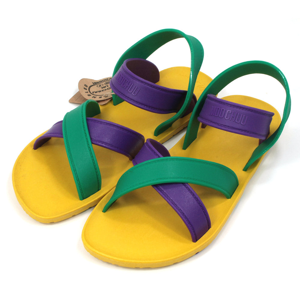 Sling back sandals with bright yellow soles and purple and green straps. All made from recycled rubber. Angled view.