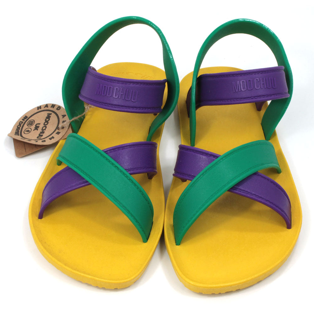 Sling back sandals with bright yellow soles and purple and green straps. All made from recycled rubber. Front view.