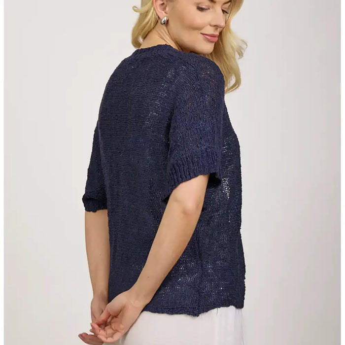 Woman wearing a navy blue knitted sweater on a white background